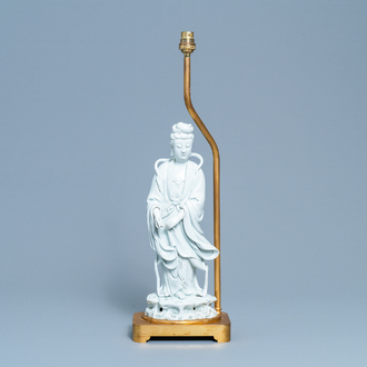 Une figure de Guanyin en porcelaine blanc de Chine montée en lampe en bronze doré, 19/20ème