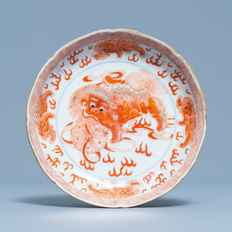 Une assiette en porcelaine de Chine en bleu, blanc et rouge de fer à décor de lions bouddhistes, marque de Qianlong, 19ème