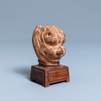 A Chinese painted pottery model of a mythical beast's head, Tang