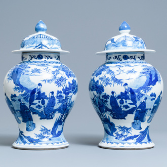 A pair of Chinese blue and white vases and covers with figures in a landscape, 19th C.