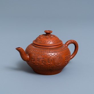 A Chinese Yixing stoneware teapot and cover with applied and impressed design, Kangxi