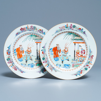 A pair of Chinese famille rose plates with figures in a garden, Yongzheng/Qianlong