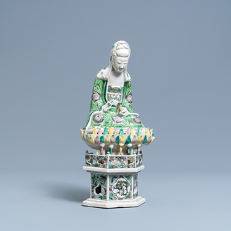 Een Chinese verte biscuit figuur van Guanyin op lotustroon, Kangxi