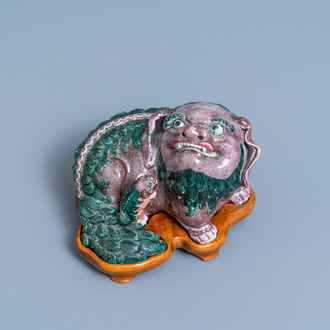 Un groupe en porcelaine de Chine figurant un lion bouddhiste et son lionceau sur socle en bois, 19ème