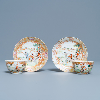 A pair of Chinese gilded famille rose 'Mongolian hunt' cups and saucers, Qianlong