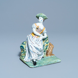 A polychrome Dutch Delft figure of a seated lady, 18th C.