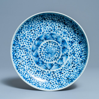 Een Chinese blauw-witte schotel met floraal decor, Ming