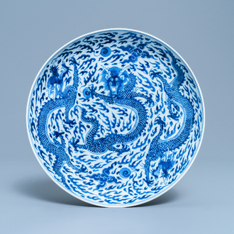 Un plat en porcelaine de Chine en bleu et blanc à décor d'un dragon, marque et époque de Kangxi