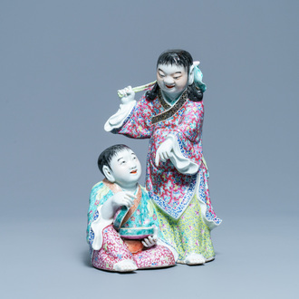 Un groupe en porcelaine de Chine famille rose figurant deux garçons avec une chauve-souris, marque en creux, République