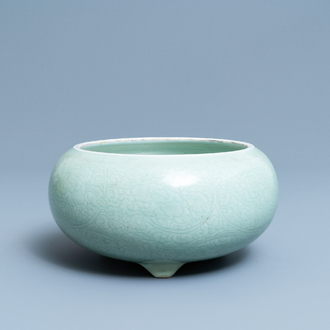 Een Chinese monochrome celadon driepotige wierookbrander met onderglazuur floraal decor, Kangxi