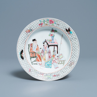 Une assiette en porcelaine de Chine famille rose à décor de figures dans un intérieur, Yongzheng