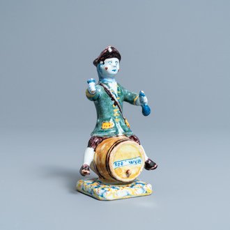 A polychrome Dutch Delft figure of a wine drinker on a barrel inscribed 'Rood Wyn', 18th C.