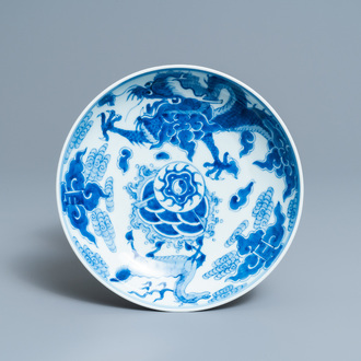 Une assiette en porcelaine de Chine en bleu et blanc à décor d'un dragon et d'un qilin, marque et époque de Yongzheng