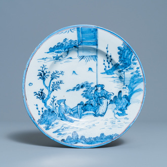 Un plat en faïence de Delft en bleu et blanc à décor de chinois dans un jardin, 17ème