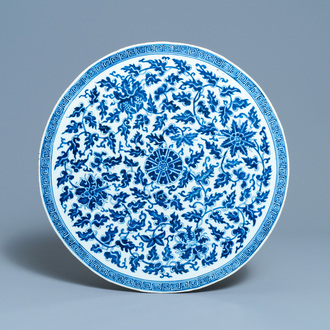 Een grote Chinese ronde blauw-witte plaquette met floraal decor, 19e eeuw