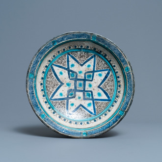 Un plat en céramique persane polychrome à décor géométrique, 14ème