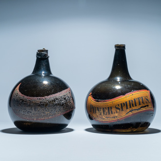 Two large dark green glass bottles with painted inscriptions, 17/18th C.