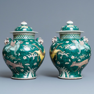 A pair of Chinese famille verte 'mythical animals' vases and covers, 19th C.