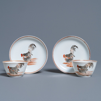 Une paire de tasses et soucoupes en porcelaine de Chine à décor de coqs et poules en grisaille et rouge de fer, Yongzheng