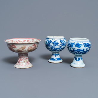Une paire de bols sur piedouche en porcelaine de Chine en bleu et blanc et un en rouge de cuivre, 19/20ème