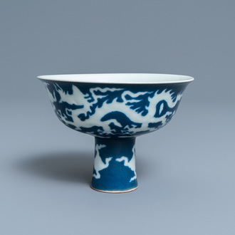 Un bol sur piedouche en porcelaine de Chine à décor incisé d'un dragon sur fond bleu, marque de Xuande, République