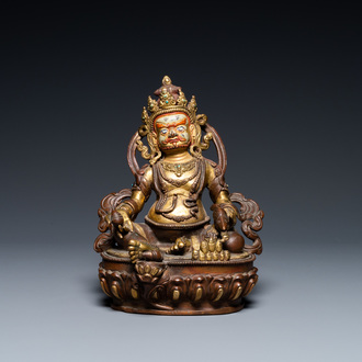 A Sino-Tibetan partly gilt bronze figure of Jambhala with inscriptions on the back, 19th C.