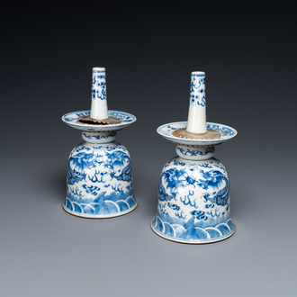 Une paire de bougeirs en porcelaine de Chine en bleu et blanc à décor de dragons, 19ème