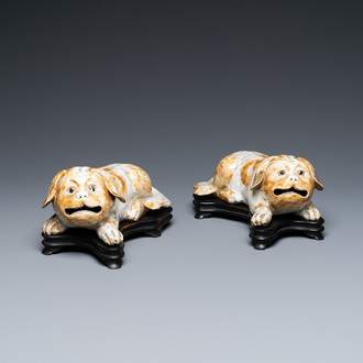 A pair of Chinese porcelain models of reclining dogs, Qianlong/Jiaqing