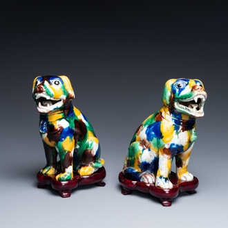 A pair of Chinese sancai-glazed dogs on wooden stands, 19th C.