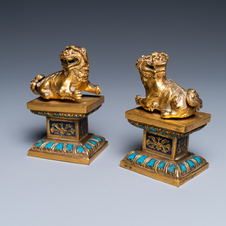 Een paar Chinese vergulde bronzen boeddhistische leeuwen op champlevé basissen, 18/19e eeuw