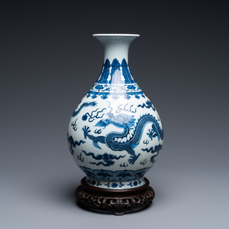 Un vase de forme 'yuhuchunping' en porcelaine de Chine en bleu et blanc sur socle en bois, marque de Qianlong, 19/20ème