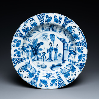 Un plat en porcelaine de Chine en bleu et blanc à décor de deux femmes et deux lapins dans un jardin, marque et époque de Kangxi