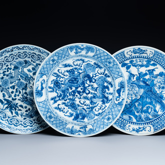 Trois plats en porcelaine de Chine en bleu et blanc à décor de dragons, phénix et de lions bouddhistes, 19ème