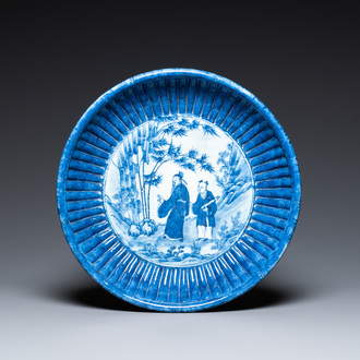 A Chinese ribbed blue and white dish with a scholar and his pupil, 19th C.