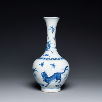 Un vase de forme bouteille en porcelaine de Chine en bleu et blanc à décor d'un tigre et deux papillons, époque Transition