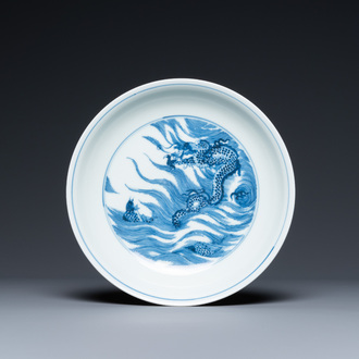Une assiette en porcelaine de Chine en bleu et blanc à décor d'un dragon et d'un carpe, marque de Kangxi, République