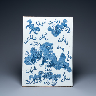 Une grande plaque en porcelaine de Chine en bleu et blanc à décor de lions bouddhistes, 19ème