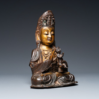 A Chinese partly gilt bronze Guanyin holding a boy, Ming