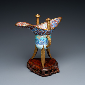 A Chinese Canton enamel and gilt bronze ritual wine vessel or 'jue' on wooden stand, 18/19th C.