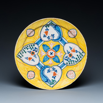 Un plat en faïence polychrome de Delft à fond jaune à décor aux quatre coeurs, 18ème