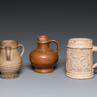 A German stoneware mug and two jugs, Raeren and Cologne, 16/17th C.