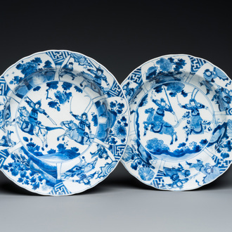 A pair of Chinese blue and white 'Mu Guiying' plates, Kangxi mark and of the period