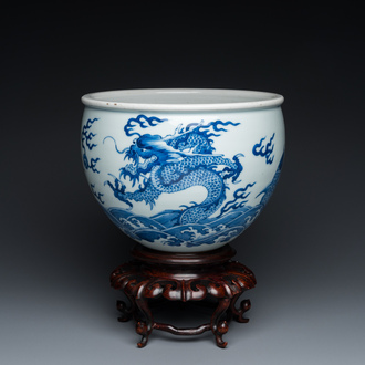 Jardinière en porcelaine de Chine en bleu et blanc à décor de dragons et de carpes sur socle en bois, 19/20ème