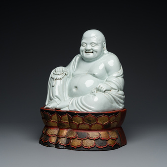 Een Chinese blanc de Chine Boeddha op gelakte en vergulde houten 'lotus' sokkel, Qianlong/Jiaqing