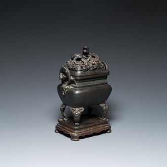 Een Chinese bronzen wierookbrander met opengewerkt 'draken' deksel op bronzen sokkel, 17e eeuw