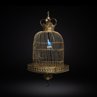 A Dutch or Flemish yellow brass bird cage with a porcelain bird, 18th and 19th C.