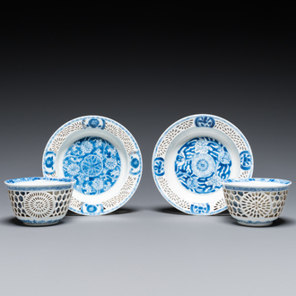 A pair of Chinese blue and white reticulated double-walled cups and saucers, Kangxi