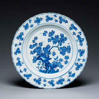 Een Chinese blauw-witte schotel met floraal decor, Kangxi merk en periode