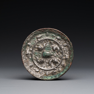Mirroir en bronze légèrement argenté à décor de lions et de vignes, Chine, Tang