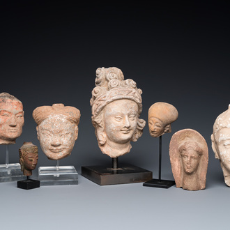 Acht diverse gesculpteerde stenen hoofden, o.a. Gandhara, Etruskisch, Japans en Chinees